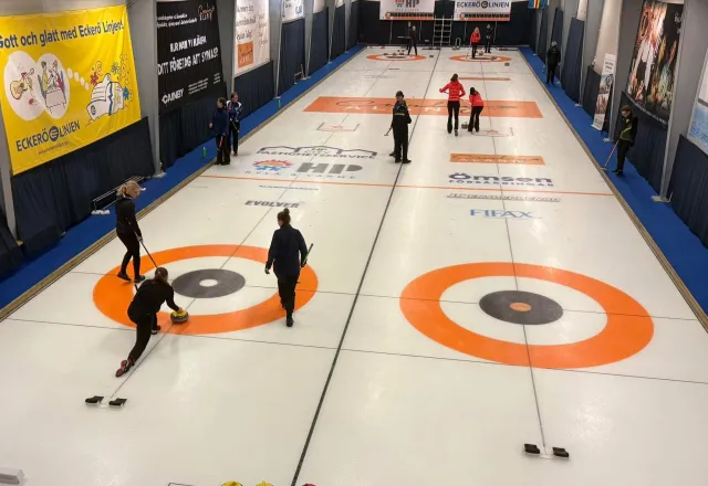 Curlingbanorna med ett lag som lägger sten 